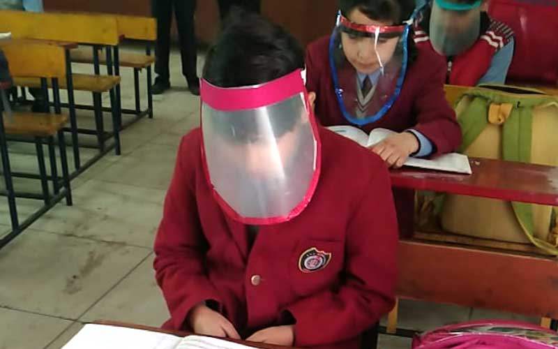 "students classroom wearing face shield to reduce covid-19 infection"