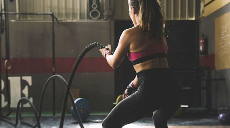 alt="A woman in gym doing HIIT workout"