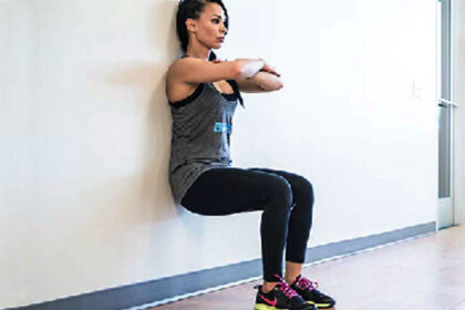 alt="a woman doing wall sits"