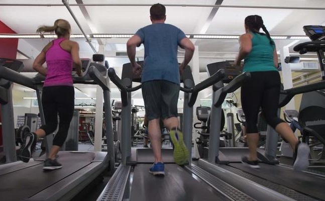 alt="Women running on treadmills at gym"